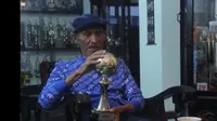 Mantan pelatih Persib Bandung, Indra Thohir, bersama trofi pelatih terbaik Asia di tahun 1995. (Istimewa/YouTube Jurnal Opah)