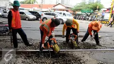 Pekerja membongkar aspal untuk mengganti bantalan rel kereta api di kawasan Stasiun Karet, Jakarta, Rabu (28/12). Perawatan dan pengecekan rutin rel kereta api itu guna menjamin keselamatan perjalanan kereta api. (Liputan6.com/Gempur M. Surya)