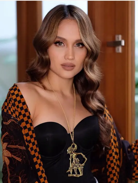 Cinta tampil dengan bustier hitam dipadukan outer batik, serta mengenakan kalung berliontin wayang.  [@claurakiehl]