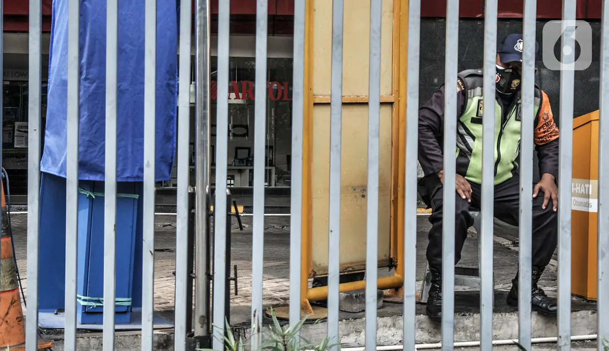 Petugas keamanan berjaga di pintu masuk saat penutupan Plaza Kenari Mas, Jakarta, Rabu (7/7/2021). Pusat elektronik tersebut ditutup sejak 6 Juli hingga 20 Juli atau sampai berakhirnya masa PPKM Darurat. (merdeka.com/Iqbal S. Nugroho)