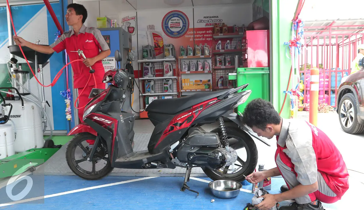 Mekanik saat membetulkan sebuah sepeda motor  saat meresmikan outlet Bright Olimart  di SPBU Cakung, Jakarta, Senin (26/10). Outlet ini merupakan pelayanan servis pengendara bermotor. (Liputan6.com/Angga Yuniar)