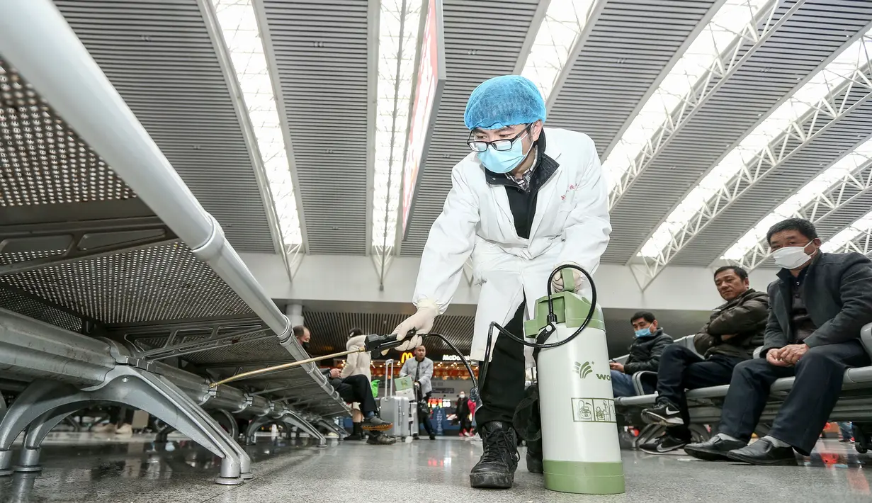 Petugas menyemprotkan cairan disinfektan di Stasiun Kereta Api Yingtan di Nanchang di Provinsi Jiangxi Tengah, China (22/1/2020). Larangan dilakukan untuk mencegah penyebaran virus mematikan tersebut ke wilayah lain maupun ke luar negeri. (AFP Photo/STR)