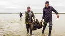 Sejumlah orang membawa pecahan tulang mammoth di Danau Pechevalavato, Yamalo-Nenets, Rusia, Rabu (22/7/2020). Fragmen kerangka mammoth tersebut ditemukan oleh para penggembala rusa lokal. (Artem Cheremisov/Governor of Yamalo-Nenets region of Russia Press Office via AP)