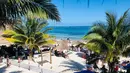 Wisatawan menikmati pantai di Puerto Morelos, negara bagian Quintana Roo, Meksiko (14/2). Puerto Morelos adalah sebuah kota dan pelabuhan di Quintana Roo, negara bagian paling timur Meksiko, di Semenanjung Yucatán. (AFP Photo/Daniel Slim)