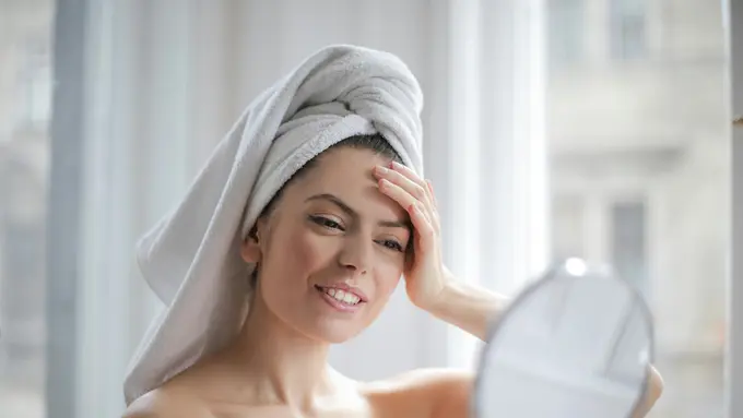 Perempuan sedang bercermin