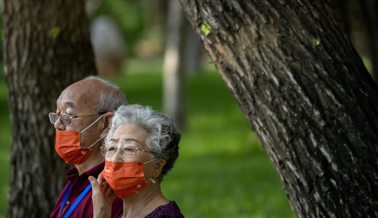 Orang-orang yang memakai masker duduk di bangku di taman umum di Beijing, Jumat (8/7/2022). Ibu kota China, Beijing, tampaknya telah membatalkan rencana untuk mengeluarkan mandat yang mengharuskan orang menunjukkan bukti vaksinasi COVID-19 untuk masuk ke ruang publik tertentu setelah penolakan di kalangan penduduk. (AP Photo/Mark Schiefelbein)