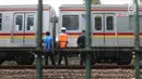 Sejumlah petugas KAI memeriksa keadaan kereta yang anjlok di dekat Stasiun Palmerah, Jakarta, Sabtu (13/10). Para penumpang terpaksa turun dan sebagian memutuskan berganti kereta karena KRL tak dapat melanjutkan perjalanan. (Liputan6.com/Herman Zakharia)