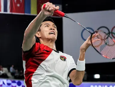 Pebulu tangkis tunggal putra Indonesia, Jonatan Christie berusaha mengembalikan kok ke arah wakil Belgia, Julien Carraggi pada laga Grup L cabang olahraga bulu tangkis Olimpiade Paris 2024 di Porte de la Chapelle Arena, Paris, Prancis, Sabtu (27/07/2024). (AFP/David Gray)