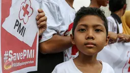 Seorang anak ikut dalam aksi sukarelawan PMI di acara car free day, Bunderan HI, Jakarta, Minggu (6/3). Ratusan sukarelawan PMI meminta DPR untuk segera mengesahkan RUU Kepalangmerahan menjadi UU Kepalangmerahan pada tahun ini.(Liputan6.com/Yoppy Renato)