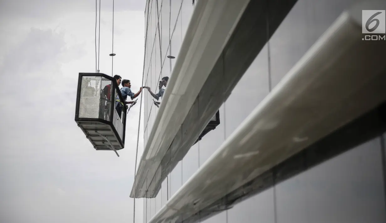 Pekerja tanpa helm keselamatan beraktivitas di gedung bertingkat di Jakarta, Rabu (15/11). Banyak kejadian kecelakaan kerja di ketinggian disebabkan karena minimnya pengetahuan dasar mengenai keselamatan kerja di ketinggian. (Liputan6.com/Faizal Fanani)
