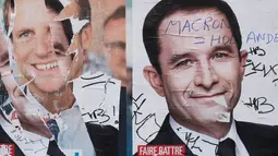 Poster Capres Prancis,  Marine Le Pen terlihat rusak di Paris, Selasa (2/5). Sejumlah poster capres Prancis lainnya juga tampak rusak yang diduga dilakukan oleh orang yang tidak suka dengan mereka. (AFP PHOTO / JOEL SAGET)