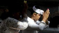 Seorang pria memanjatkan doa saat mengikuti sembahyang perayaan hari raya Galungan di sebuah pura di Bali, Rabu (4/1/2023). Hari Galungan pada tahun ini bertepatan pada 4 Januari. Galungan diperingati sebagai ucapan syukur. (AP Photo/Firdia Lisnawati)