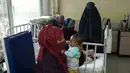 Lina menggendong bayinya, Osman, saat menjalani perawatan di bangsal gizi buruk RS Anak Nasional Ataturk, Kabul, Afghanistan, 2 Desember 2021. Menurut PBB dari awal November, hampir 24 juta orang di Afghanistan, sekitar 60 persen populasi, menderita kelaparan akut. (AP Photo/Petros Giannakouris)