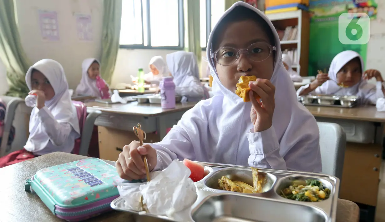 Seorang siswi sekolah dasar sedang menikmati menu makan bergizi gratis di Sekolah Dasar Negeri 01&02, Susukan, Jakarta, Senin (6/1/2025). (Liputan6.com/Herman Zakharia)