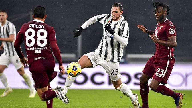 Gelandang Juventus, Adrien Rabiot, berusaha melewati pemain Torino pada laga Liga Italia di Stadion Allianz, Minggu (6/12/2020). Juventus menang dengan skor 2-1. (Marco Alpozzi/LaPresse via AP)