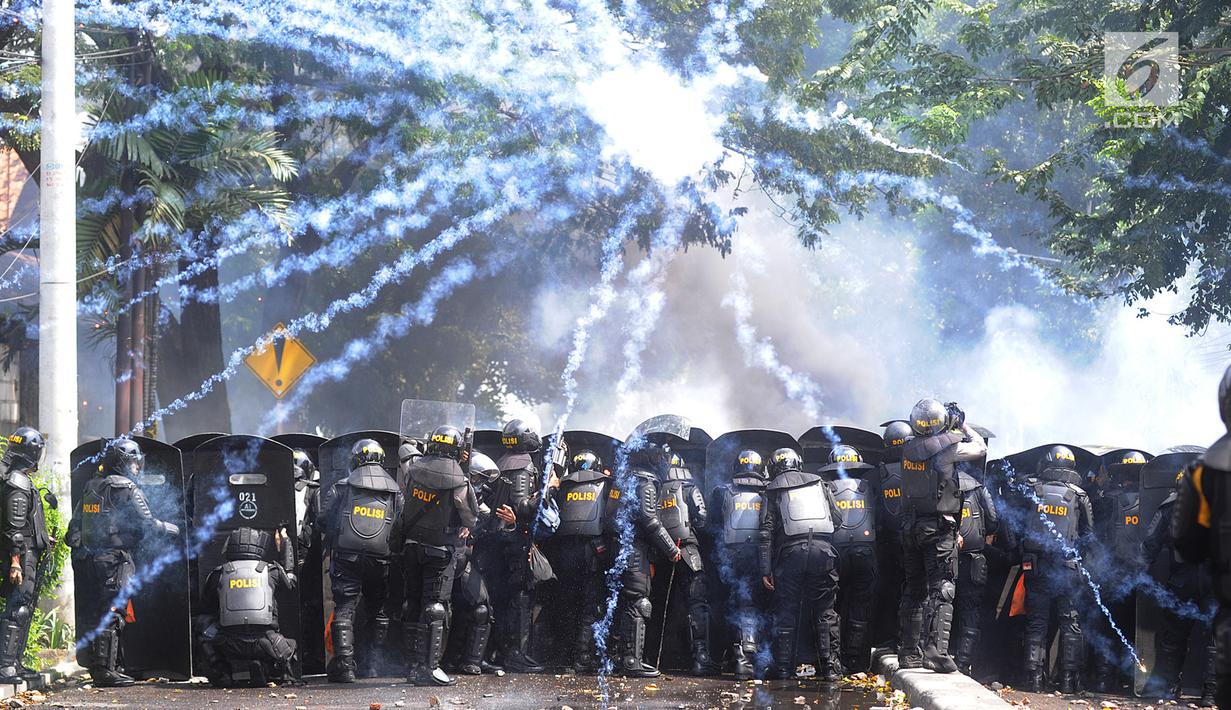 Sejumlah kepolisian berlindung saat bentrok dengan massa aksi 22 Mei sebelum terjadi pembakaran bis milik Brimob di kawasan Tanah Abang,  Jakarta, Rabu (22/5/2019). (merdeka.com/Arie Basuki)