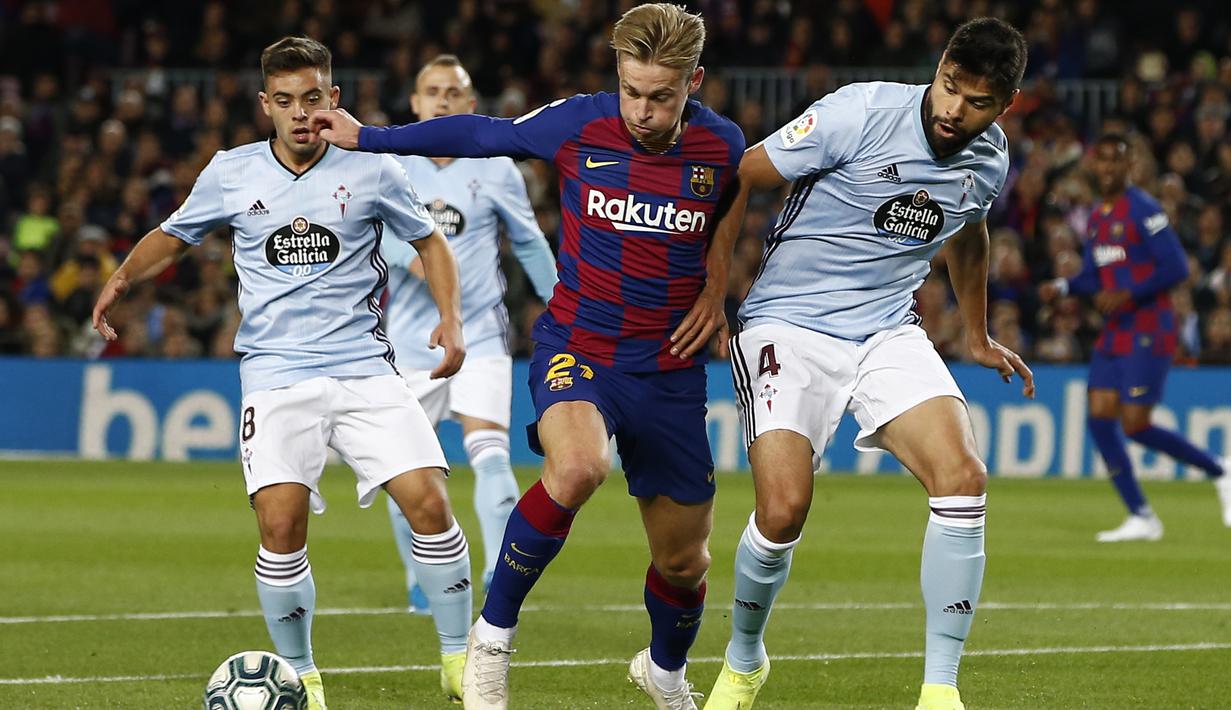 Gelandang Barcelona, Frenkie de Jong (tengah) membawa bola dari kawalan dua pemain Celta Vigo, Nestor Araujo dan Fran Beltran pada pertandingan lanjutan La Liga Spanyol di stadion Camp Nou (9/11/2019). Barcelona menang telak 4-1 atas Vigo. (AP Photo/Joan Monfort)