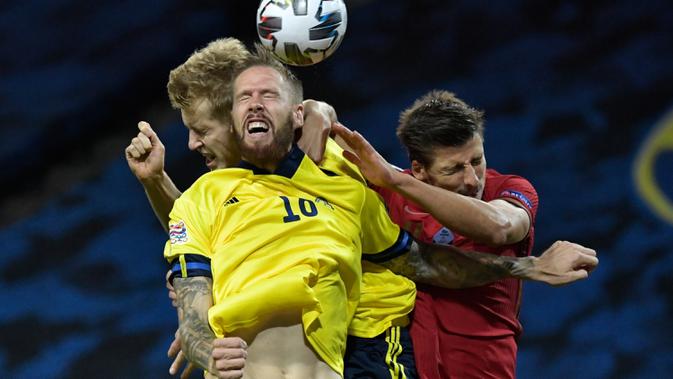 Gelandang timnas Swedia, Emil Forsberg berebut bola dengan pemain timnas Portugal, Pontus Jansson dan Ruben Dias pada laga UEFA Nations League A Group 3 di Friends Arena, Selasa (8/9/2020). Portugal kalahkan Swedia 2-0 lewat sepasang gol yang dicetak Cristiano Ronaldo (Janerik Henriksson /TT via AP)