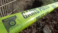 Garis polisi dipasang di lokasi makam yang dibongkar orang tak dikenal di Bekasi. (Bam Sinulingga/Liputan6.com)
