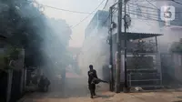 Petugas melakukan pengasapan atau fogging di kawasan perumahan Jalan Delima Raya, Jakarta Barat, Senin (25/10/2021). Pemyemprotan guna membasmi nyamuk Aedes aegypti yang menyebabkan penyakit demam berdarah (DBD) saat musim hujan di kawasan pemukiman warga. (Liputan6.com/Johan Tallo)