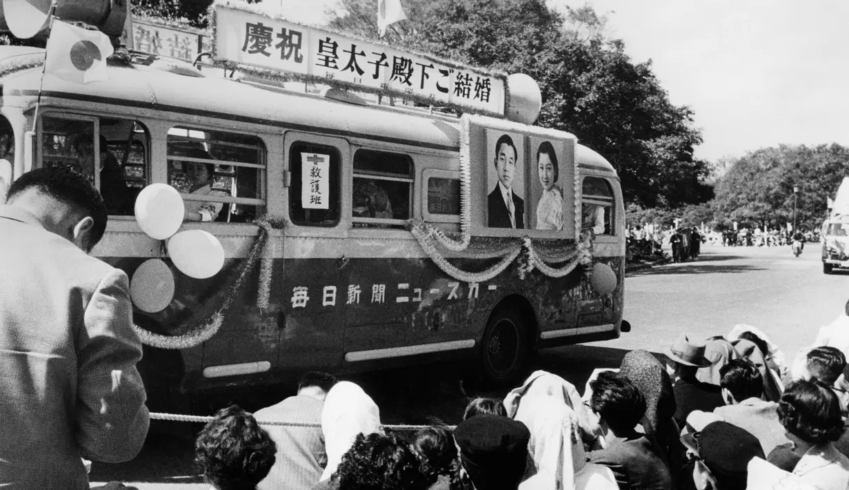 Sejumlah warga melihat sebuah bus dengan foto Pangeran Mahkota Jepang Akihito dan istrinya Michiko Shoda selama merayakan pernikahan mereka pada April 1959. (AFP Photo)