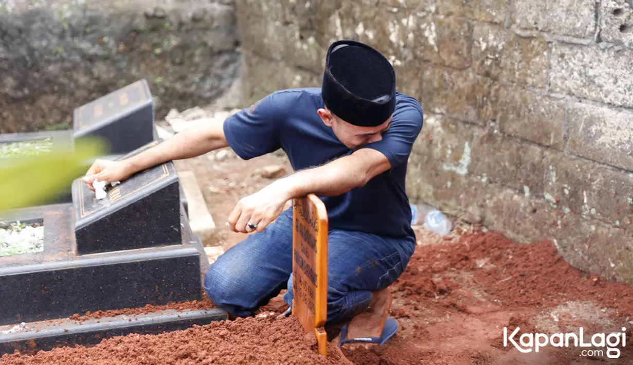 Ramzi tertunduk di atas pusara sang ibu. Suami Avi Basalamah itu berulang kali mengusap air mata yang membasahi pipinya. [Foto: Budy Santoso/KapanLagi.com]