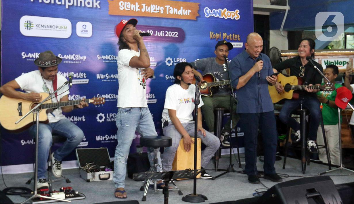 Grup band Slank bernyanyi bersama Menteri Koperasi dan UKM Teten Masduki (kanan depan) usai peluncuran Slankops di Basecamp Slank, Jakarta, Selasa (19/7/2022). Slank bersama Menteri Koperasi dan UKM Teten Masduki dan Menteri BUMN Erick Thohir bernyanyi bersama membawakan lagu 'Ku Tak Bisa' dan 'Balikin'. (Liputan6.com/Herman Zakharia)