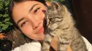Maria Zhang berpose bersama kucingnya. Menggemaskan, Maria memamerkan kulit glowingnya di bawah sinar matahari, dengan sentuhan winged-eyeliner tipis. [Foto: Instagram/mariaxzhang]