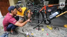 Ngadiman, jasa service sepeda panggilan memperbaiki dan merawat sepeda salah satu konsumennya di Kemandoran, Jakarta, Kamis (16/06/2022). Ngadiman, yang berdomisili di Pasar Minggu Jakarta Selatan ini memasang jasa service sepeda panggilan mulai dari Rp50 - Rp200 ribu belum termasuk suku cadang. (Liputan6.com/Fery Pradolo)