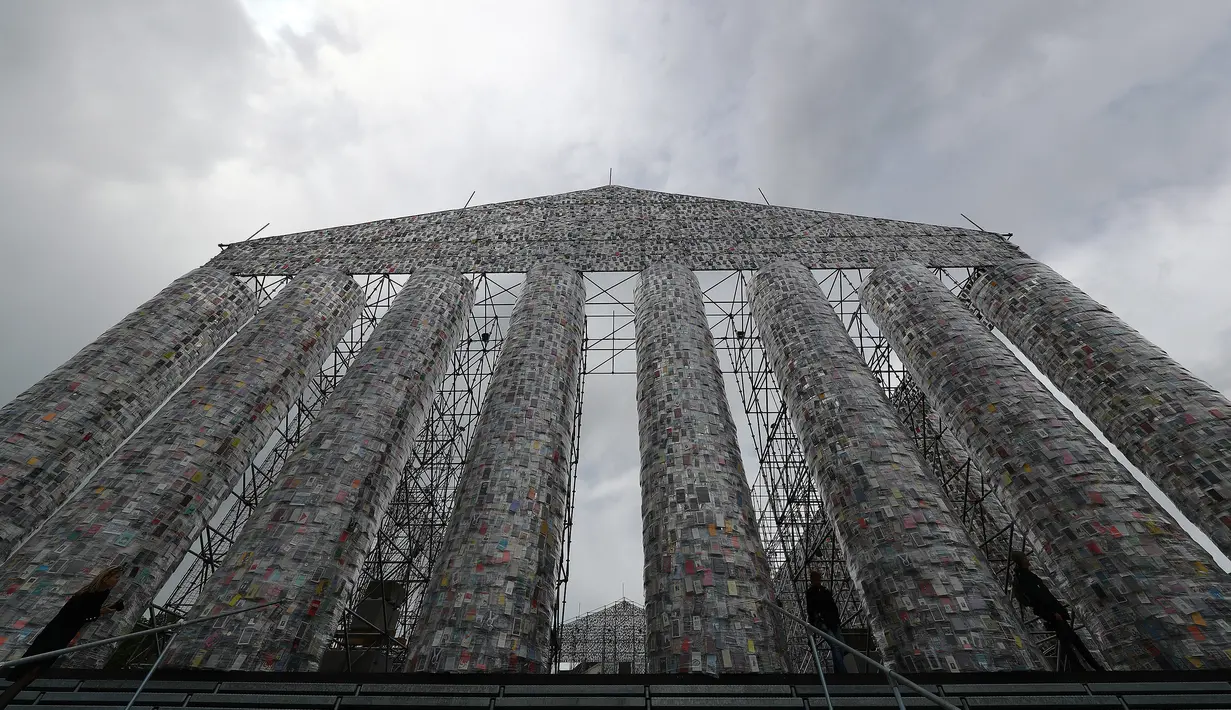 Wanita berjalan di depan "Temple of books" atau Kuil Buku jelang pembukaan pameran seni terbesar Jerman "Documenta 14" di Kassel, Jerman (7/6). Proyek karya seniman Marta Minujin ini terbuat dari ribuan buku dan rangkai besi. (Reuters/Kai Pfaffenbach)