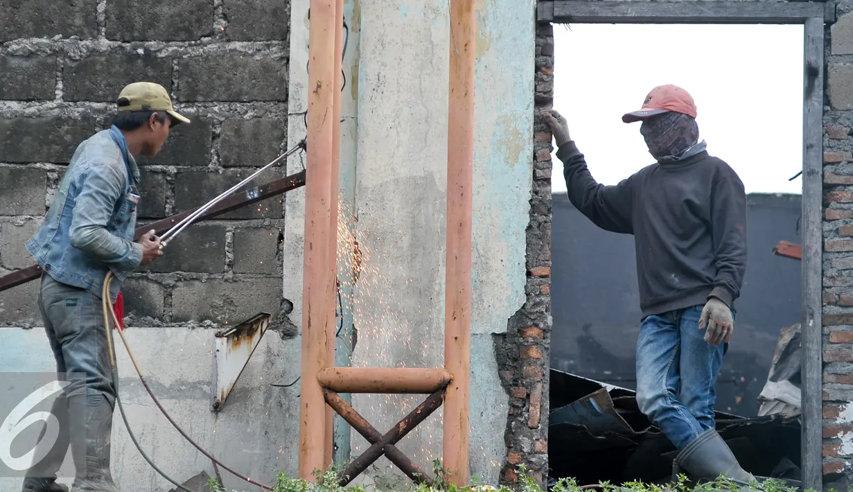 Pekerja melakukan pemotongan besi di bangunan Pasar Rumput, Manggarai, Jakarta, Senin (17/10). Pasar yang memiliki luas sekitar 22.710 meter persegi akan dibangun menjadi rusun dengan berbagai fasilitas. (Liputan6.com/Yoppy Renato)