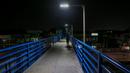 Pejalan kaki berjalan di atas jembatan penyeberangan selama pemberlakuan jam malam di Quezon City, 18 Maret 2020. Presiden Filipina Rodrigo Duterte menyatakan status bencana nasional selama enam bulan di tengah meningkatnya kasus virus corona Covid-19 di negara itu. (Xinhua/Rouelle Umali)