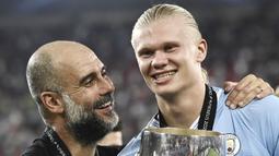 Pelatih Manchester City,  Pep Guardiola, bersama Erling Haaland saat perayaan juara UEFA Super Cup 2023 di Stadion Georgios Karaiskakis, Kamis (17/8/2023). Laga Piala Super Eropa kali ini berakhir imbang 1-1 dalam 90 menit, Man City menang 5-4 di babak adu penalti. (AFP/Spyros Bakalis)