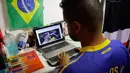 Carlos Junior membaca berita sepak bola online menggunakan braille dirumahnya di Sao Paulo, Brasil, (2/7). Dengan keadaan yang buta dan tuli, tidak membuat junior patah semangat untuk merasakan kecintaanya terhadap sepak bola. (AP Photo / Nelson Antoine)