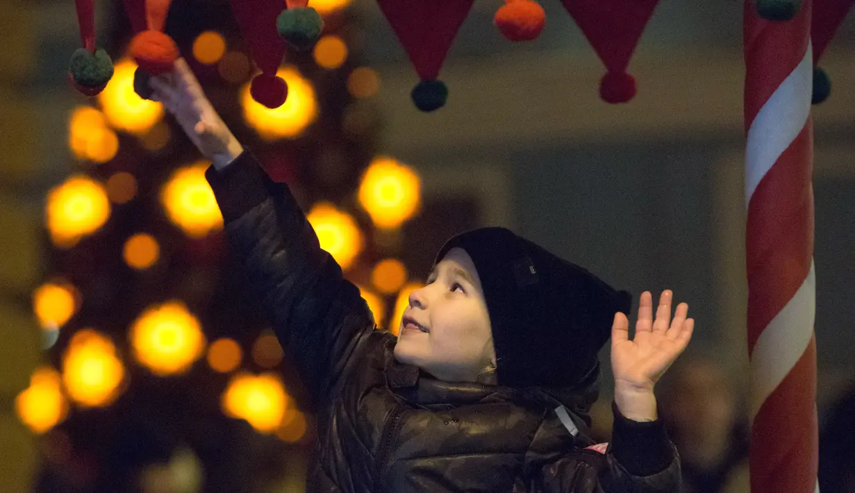 Seorang anak bermain di pasar Natal di St. Petersburg, Rusia (20/12/2020). Di tempat-tempat ini, keluarga Romanova hidup selama hampir 4 generasi. (Xinhua/Irina Motina)