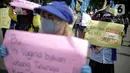 Massa Gabungan Serikat Buruh Indonesia (GSBI) membawa pembalut wanita saat berunjuk rasa di kawasan Patung Kuda, Jakarta, Senin (16/11/2020). GSBI meminta pemerintah mencabut UU Cipta Kerja serta menaikkan upah buruh 2021 sesuai kebutuhan rill buruh dan keluarga. (Liputan6.com/Faizal Fanani)