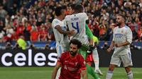 Kiper Real Madrid, Thibaut Courtois (tengah) melakukan selebrasi bersama rekannya usai berhasil menepis tendangan dari pemain Liverpool, Mohamed Salah saat laga final Liga Champions antara Liverpool melawan Real Madrid yang berlangsung di Stade de France, Saint Denis, Sabtu, 28 Mei 2022 waktu setempat. (AFP/Paul Ellis)