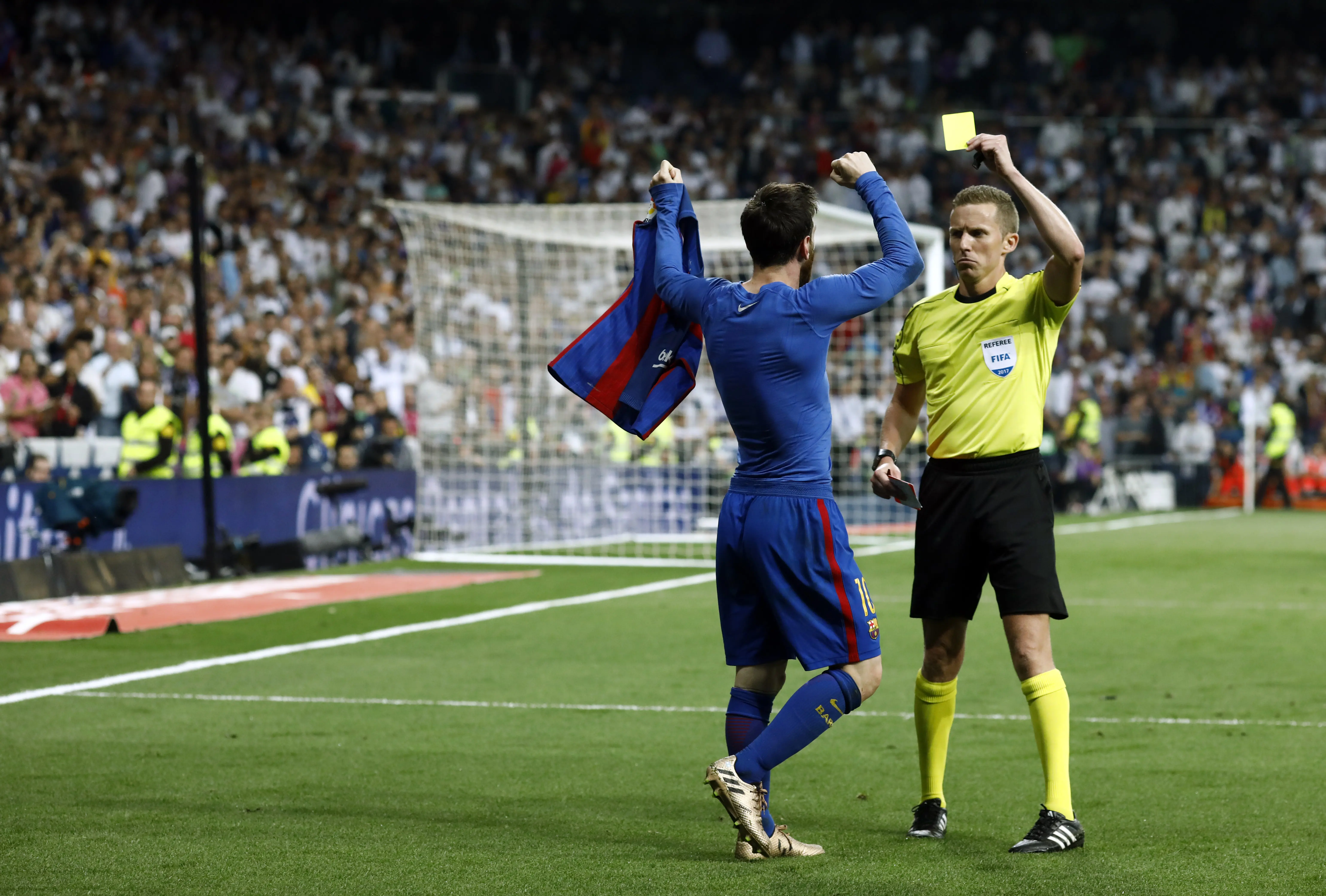 Lionel Messi mendapatkan kartu kuning usai berselebrasi dengan melepas jerseynya kala mencetak gol penentu kemenangan 3-2 Barcelona atas Real Madrid. (OSCAR DEL POZO / AFP)