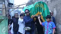 Komedian Komeng menggotong keranda jenazah anak ketiganya, Cantika Alhayu Aldi, menuju pemakaman keluarga di Citeureup, Bogor, Minggu (28/8). Caca, sapaan Cantika, meninggal dunia di usia 10 tahun lantaran sakit. (Liputan6.com/Herman Zakharia)
