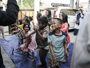 Badan Penanggulangan Bencana Daerah (BPBD) Provinsi DKI Jakarta memberikan bantuan layanan dukungan psikososial kepada anak-anak anak penyintas kebakaran Manggarai di Jalan Manggarai Utara 2, RT 01/01, Kelurahan Manggarai, Tebet, Minggu (17/12/2023). (Liputan6.com/Faizal Fanani)