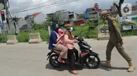 Petugas Satpol PP memberhentikan pengendara motor saat melintasi Pos Pengawasan Larangan Mudik di Cigombong, Bogor, Rabu (29/4/2020). Polres Bogor terus melakukan penyekatan  mencegat pemudik sekaligus PSBB mengantsipasi penyebaran virus Covid-19. (merdeka.com/Arie Basuki)