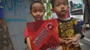 Seorang anak menunjukan buku yang dibagikan Presiden Joko Widodo seusai acara makan siang bersama kepala negara serta delegasi negara-negara peserta Konferensi Asia Afrika di Jalan Cicendo, Bandung, Jumat (24/4/2015). (Liputan6.com/Faizal Fanani)