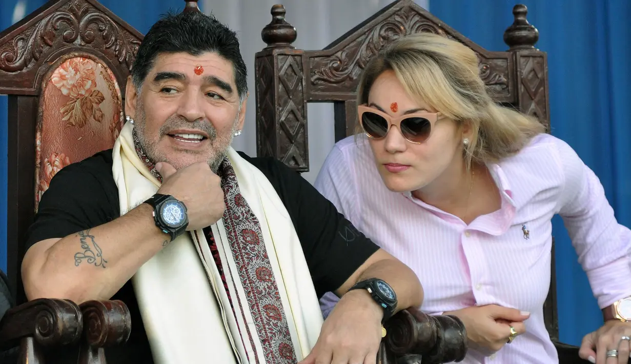 Legenda sepak bola, Diego Maradona, didampingi kekasihnya, Rocio Oliva, saat mengunjungi Kolkata, Senin (11/12/2017). Kunjungan ini dilakukan pria asal Argentina itu dalam rangkaian liburan. (AFP/Stringer)