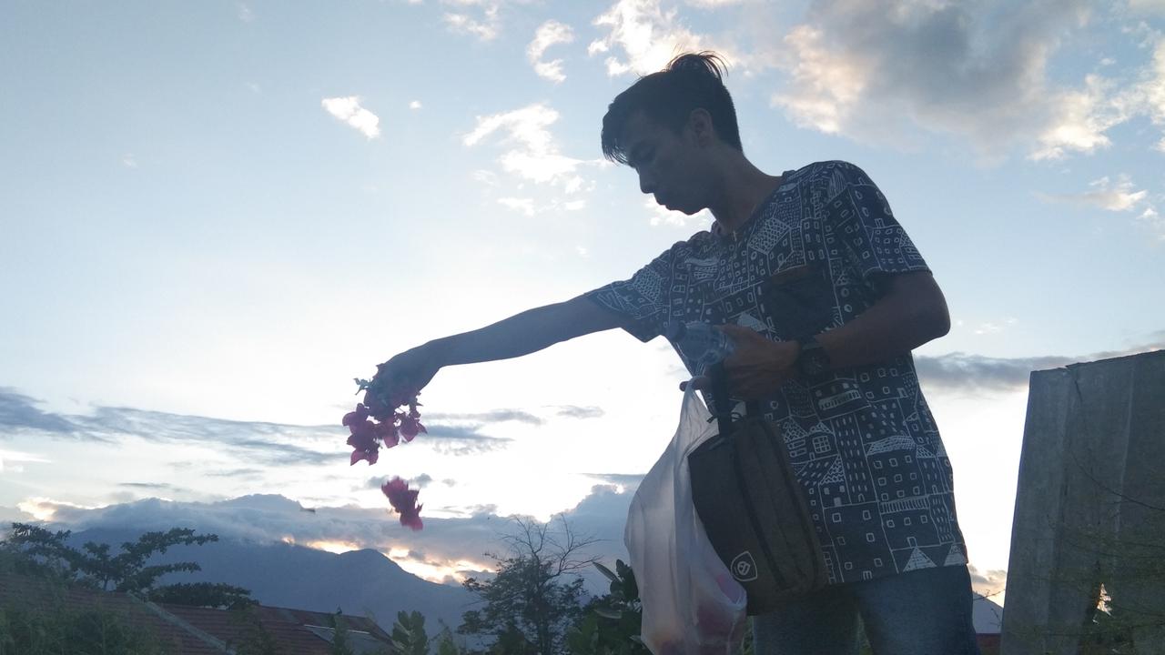 Seorang penyintas tragedi Likuefaksi menaburkan bunga, sebagai sebentuk doa dan harapan pada 2020. (Foto: Liputan6.com/Heri Susanto)