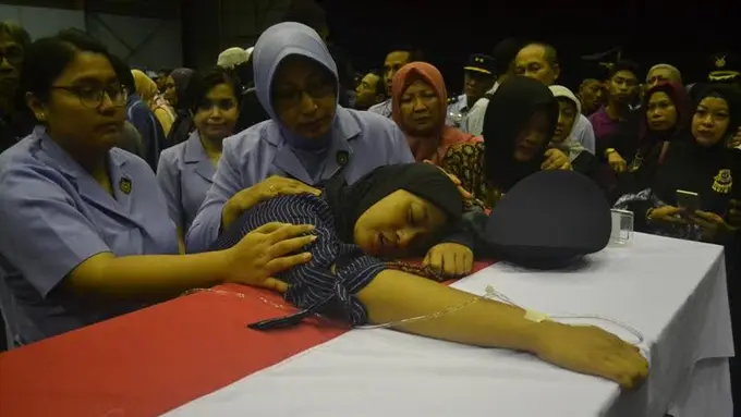 Istri korban pesawat Hercules jatuh di Wamena memeluk peti jenazah suaminya. 