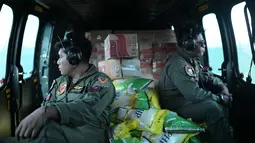 Distribusi bantuan sebagian besar dilakukan melalui jalur udara menggunakan helikopter untuk menjangkau daerah-daerah yang masih terisolasi. Tampak dalam foto, personel TNI AU duduk di dalam helikopter untuk mendistribusikan bantuan ke daerah terdampak banjir di Aceh Tengah, Sabtu 6 Desember 2025. (AP Photo/Reza Saifullah)