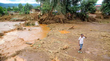 Seorang anak berjalan melewati area yang tersapu air setelah bendungan jebol di Desa Kamuchiri Mai Mahiu, Kabupaten Nakuru, Kenya, Senin 29 April 2024. (AP Photo/Patrick Ngugi)