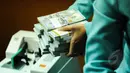 Aktivitas penukaran uang di PT Ayu Masagung, Jakarta, Senin (9/3/2015). Pada awal perdagangan di pasar spot, rupiah dibuka pada level 12.994 atau melemah 18 poin dibanding penutupan akhir pekan lalu di posisi 12.976. (Liputan6.com/Faizal Fanani)