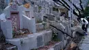 Seorang wanita membersihkan makam kerabat saat Festival Chung Yeung atau dikenal juga Tomb Sweeping Day di Hong Kong, 17 Oktober 2018. Pada saat perayaan, warga keturunan China mengunjungi dan membersihkan makam-makam leluhur mereka. (AP/Vincent Yu)