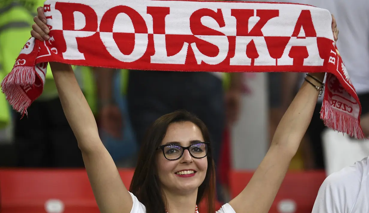 Suporter wanita tersenyum sambil membentangkan syal sebelum pertandingan grup H Piala Dunia 2018 antara Polandia melawan Senegal di Stadion Spartak di Moskow, Rusia (19/6). Dalam pertandingan ini Polandia takluk atas Senegal 2-1. (AFP Photo/Franck Fife)